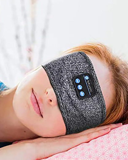 Redhead woman wearing a headband with built-in earphones listening to music while sleeping